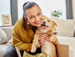 Look who found a new home. Shot of a young woman sitting at home with an adorable little dog